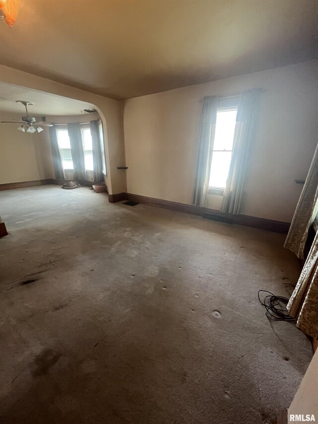 1109 S Michigan St, Davenport, IA 52802 - unfurnished room featuring baseboards, arched walkways, carpet floors, and ceiling fan