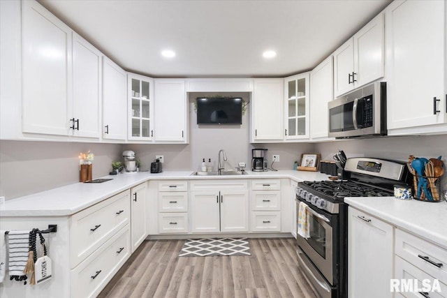 306 Myra Pl, Clinton, IA 52732 - kitchen with stainless steel appliances, a sink, light wood-type flooring, white cabinetry, and light countertops