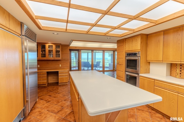 7 Sharon Ln, Fulton, IL 61252 - kitchen featuring stainless steel appliances, light countertops, a kitchen island, glass insert cabinets, and light tile patterned floors