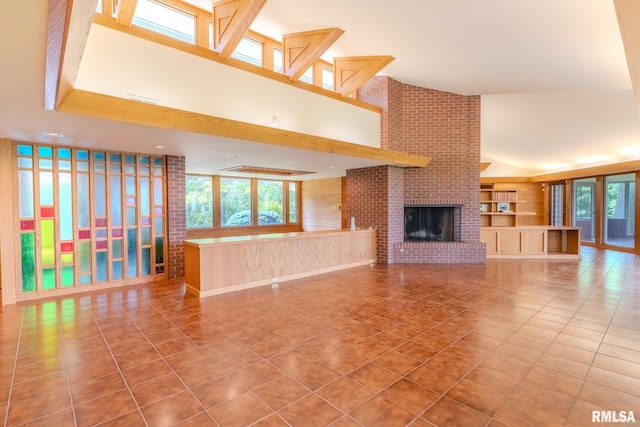 7 Sharon Ln, Fulton, IL 61252 - unfurnished living room featuring tile patterned flooring, a towering ceiling, a fireplace, and built in shelves