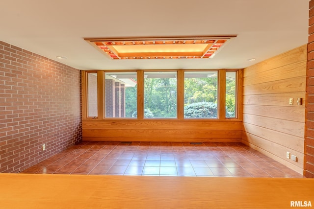 7 Sharon Ln, Fulton, IL 61252 - empty room featuring brick wall, tile patterned flooring, and wooden walls