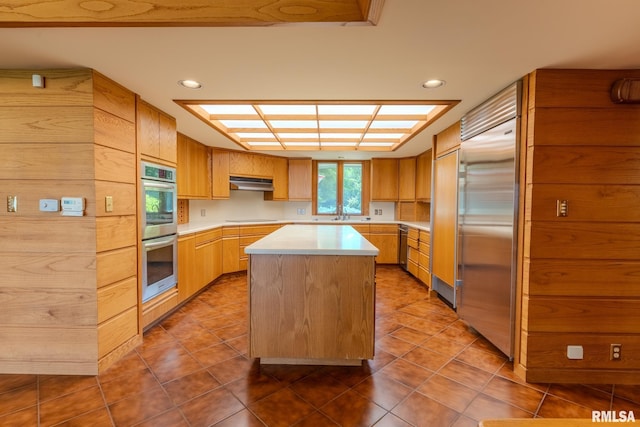 7 Sharon Ln, Fulton, IL 61252 - kitchen featuring stainless steel appliances, light countertops, a kitchen island, tile patterned floors, and under cabinet range hood