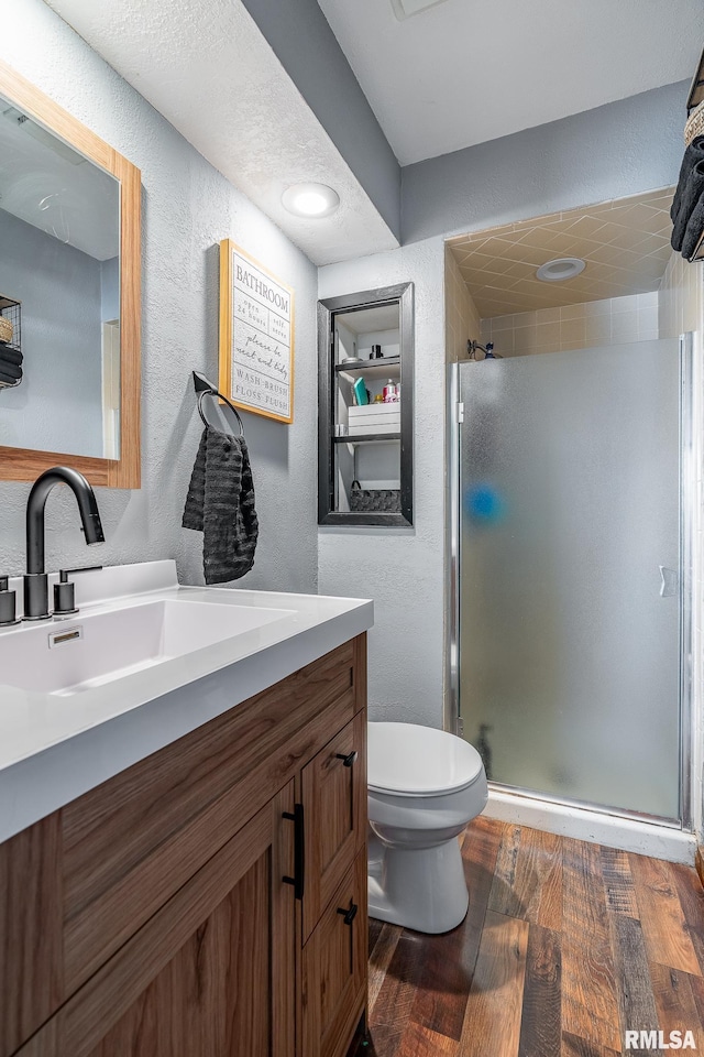 3436 Ridge Ct, Davenport, IA 52806 - full bathroom featuring a textured wall, vanity, a stall shower, and wood finished floors