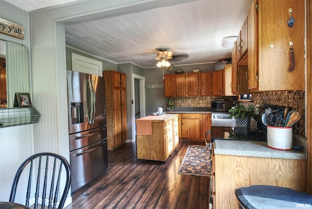 115 4th St, Fulton, IL 61252 - kitchen featuring appliances with stainless steel finishes, dark wood-style floors, tasteful backsplash, brown cabinets, and a ceiling fan