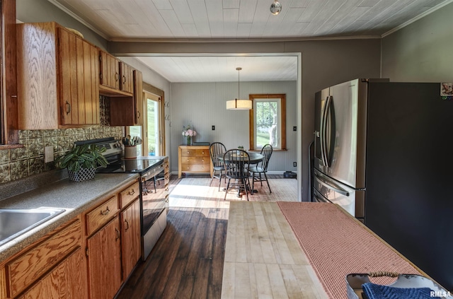 115 4th St, Fulton, IL 61252 - kitchen with electric range oven, healthy amount of natural light, brown cabinetry, and ornamental molding