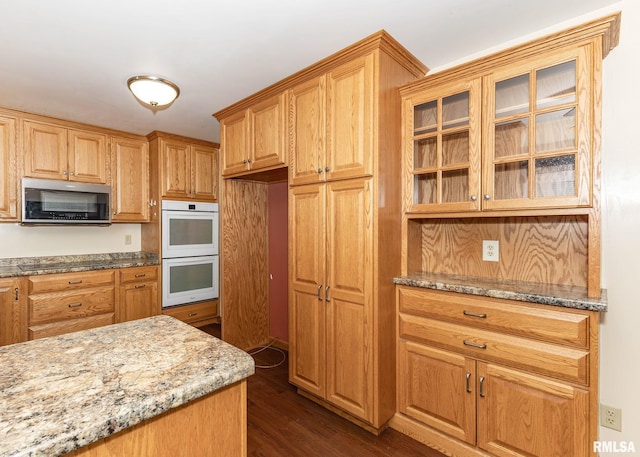 2678 170th Ave, Sherrard, IL 61281 - kitchen with stainless steel microwave, double oven, light stone counters, glass insert cabinets, and dark wood-style flooring