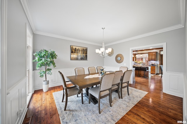 5 High Point Pl, Bettendorf, IA 52722 - dining room featuring crown molding, a chandelier, wainscoting, a decorative wall, and dark wood-type flooring
