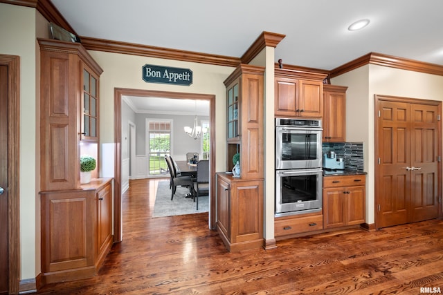 5 High Point Pl, Bettendorf, IA 52722 - kitchen featuring double oven, ornamental molding, dark wood finished floors, brown cabinetry, and glass insert cabinets