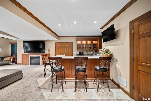 5 High Point Pl, Bettendorf, IA 52722 - indoor wet bar with crown molding, recessed lighting, a glass covered fireplace, and light colored carpet