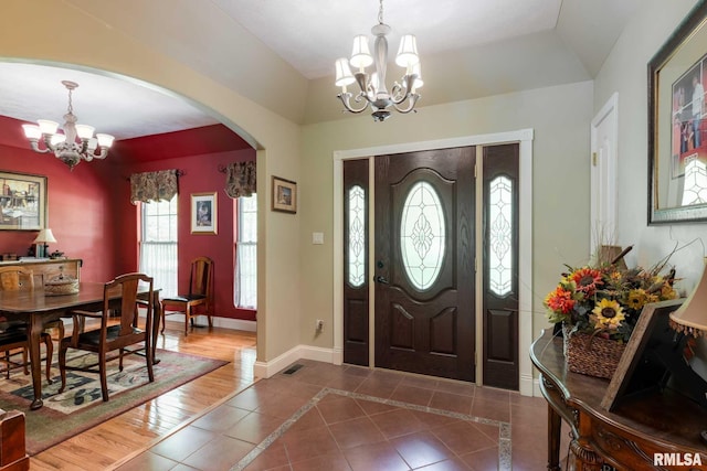 1300 W Brewster Rd, Herrin, IL 62948 - tiled foyer featuring a chandelier, arched walkways, lofted ceiling, and inlaid floor details