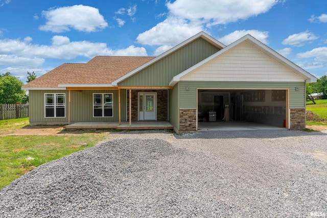 109 Brase St, Marion, IL 62959 - view of front facade with driveway, a garage, roof with shingles, a porch, and stone siding