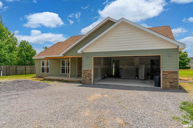 109 Brase St, Marion, IL 62959 - view of front of house featuring stone siding, a shingled roof, an attached garage, and a porch