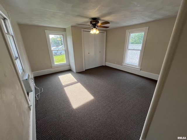 212 S E St, Cambridge, IL 61238 - unfurnished bedroom with dark colored carpet, a ceiling fan, a wall mounted AC, and a closet