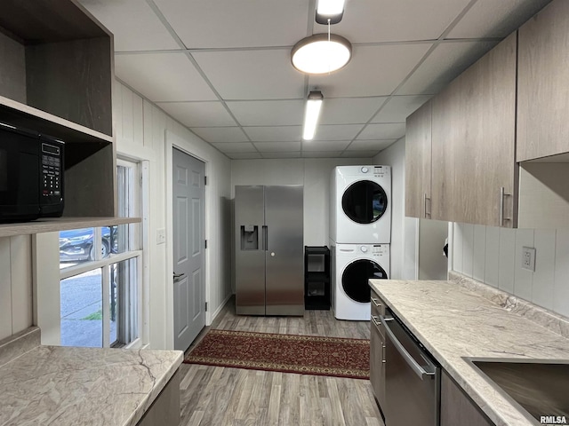 212 S E St, Cambridge, IL 61238 - kitchen featuring appliances with stainless steel finishes, stacked washer and clothes dryer, a paneled ceiling, light wood-style flooring, and open shelves