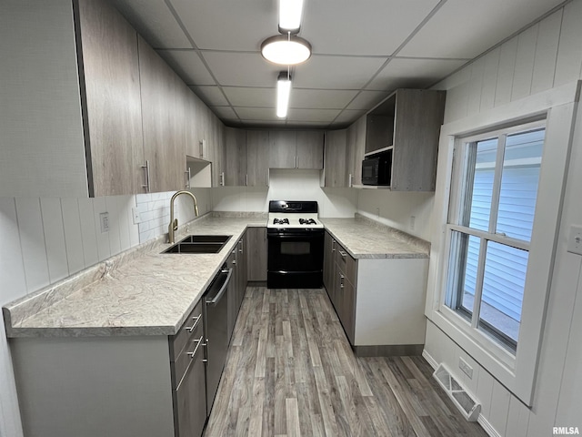 212 S E St, Cambridge, IL 61238 - kitchen with range with gas cooktop, black microwave, light wood-style flooring, a paneled ceiling, and light countertops