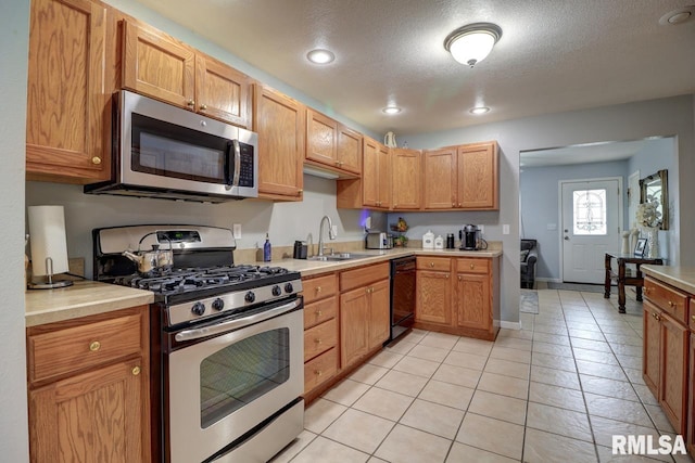 2410 Barker St, Clinton, IA 52732 - kitchen featuring stainless steel appliances, light countertops, light tile patterned flooring, recessed lighting, and a textured ceiling