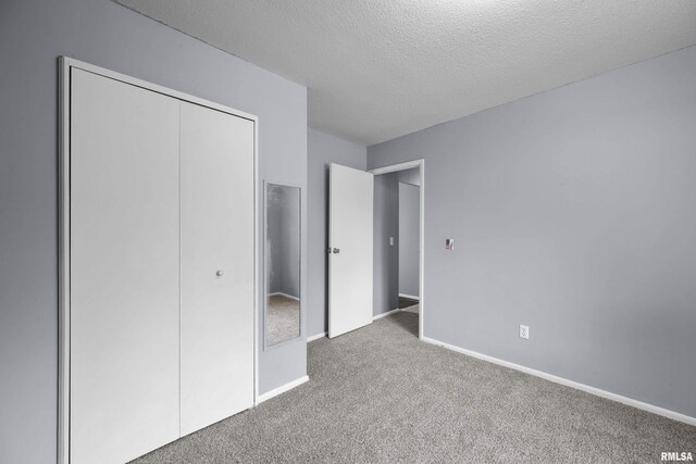 409 W 30th Ave, Milan, IL 61264 - unfurnished bedroom featuring carpet, a closet, and a textured ceiling