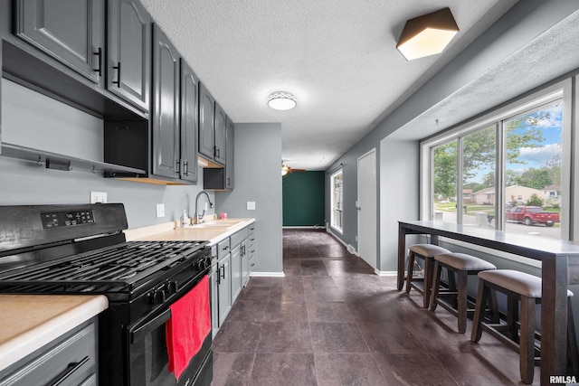409 W 30th Ave, Milan, IL 61264 - kitchen with black range with gas stovetop, light countertops, gray cabinets, a ceiling fan, and a textured ceiling