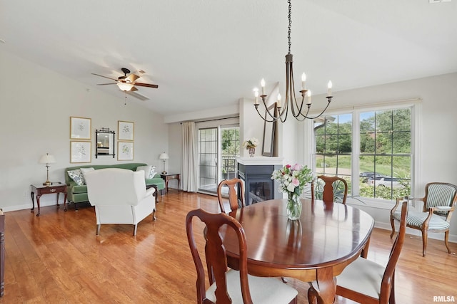 1237 Kimberly Rd, Bettendorf, IA 52722 - dining room with lofted ceiling, plenty of natural light, a chandelier, a glass covered fireplace, and light wood-type flooring