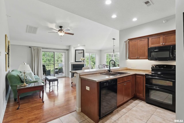 1237 Kimberly Rd, Bettendorf, IA 52722 - kitchen with black appliances, open floor plan, a peninsula, brown cabinets, and recessed lighting
