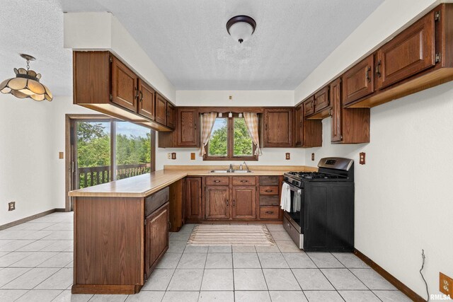 3796 160th St, Bryant, IA 52727 - kitchen with gas stove, a textured ceiling, a peninsula, light countertops, and healthy amount of natural light