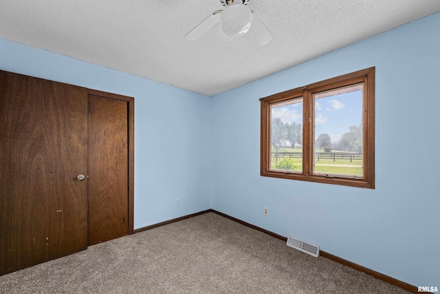 3796 160th St, Bryant, IA 52727 - unfurnished bedroom featuring carpet flooring, ceiling fan, and a textured ceiling