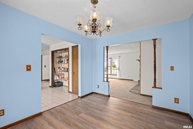 3796 160th St, Bryant, IA 52727 - unfurnished room with a chandelier and wood finished floors