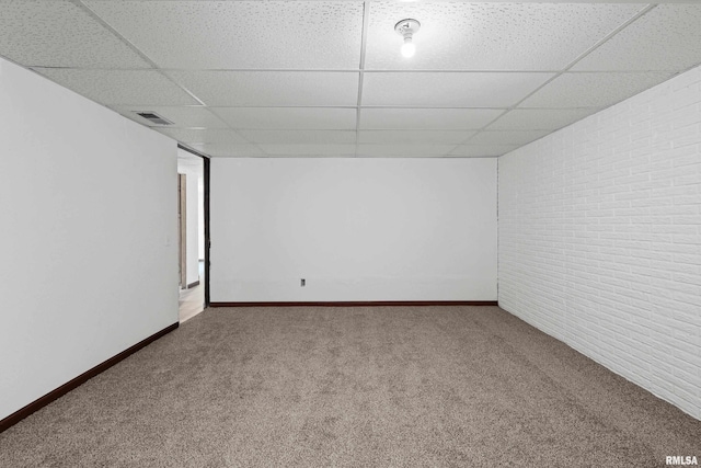 3796 160th St, Bryant, IA 52727 - unfurnished room with a paneled ceiling, carpet floors, and brick wall