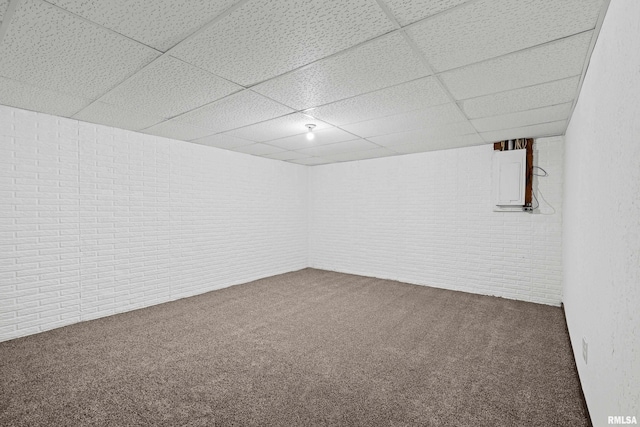 3796 160th St, Bryant, IA 52727 - finished basement with a paneled ceiling, brick wall, and carpet