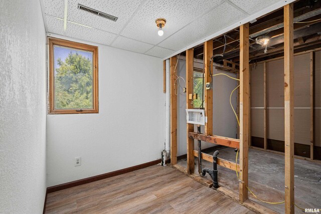 3796 160th St, Bryant, IA 52727 - below grade area with wood finished floors, a paneled ceiling, and a textured wall