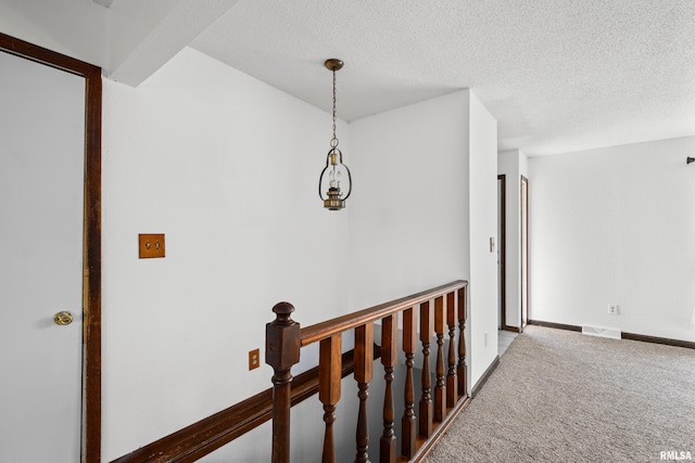 3796 160th St, Bryant, IA 52727 - hallway with carpet floors, a textured ceiling, and an upstairs landing