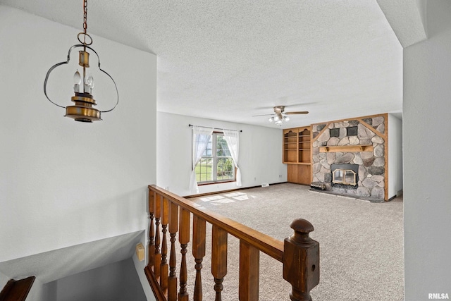 3796 160th St, Bryant, IA 52727 - living area with a textured ceiling, a ceiling fan, carpet, a fireplace, and built in features