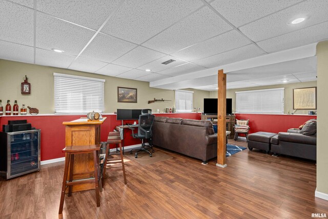 404 34th Ave, East Moline, IL 61244 - living room featuring a drop ceiling, wood finished floors, wine cooler, a bar, and an office area