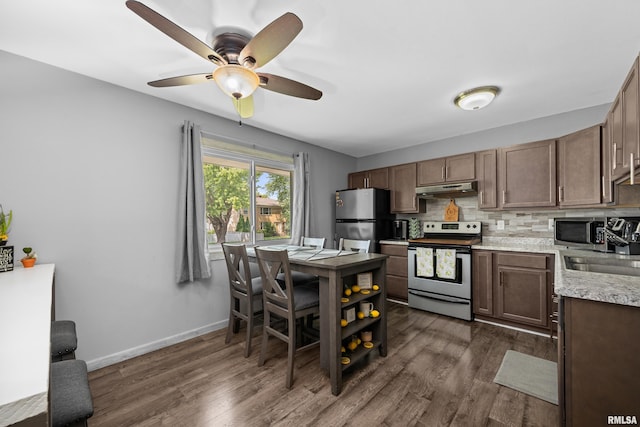 404 34th Ave, East Moline, IL 61244 - kitchen with appliances with stainless steel finishes, under cabinet range hood, light countertops, and dark wood finished floors