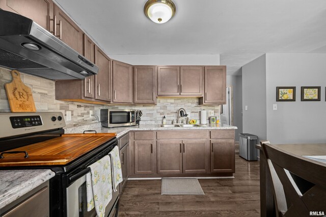 404 34th Ave, East Moline, IL 61244 - kitchen with appliances with stainless steel finishes, extractor fan, dark wood-style floors, and backsplash