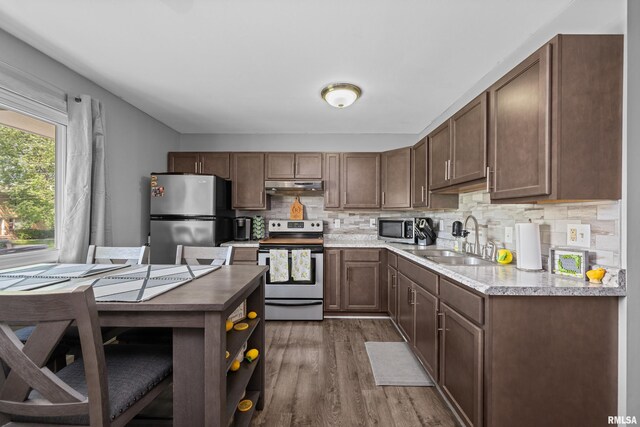 404 34th Ave, East Moline, IL 61244 - kitchen with stainless steel appliances, under cabinet range hood, dark wood finished floors, tasteful backsplash, and light countertops