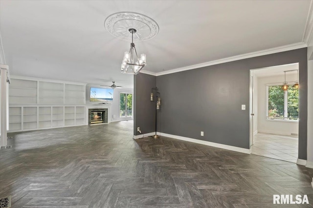 4319 7th Ave, Moline, IL 61265 - unfurnished living room featuring ceiling fan, a chandelier, a glass covered fireplace, plenty of natural light, and crown molding