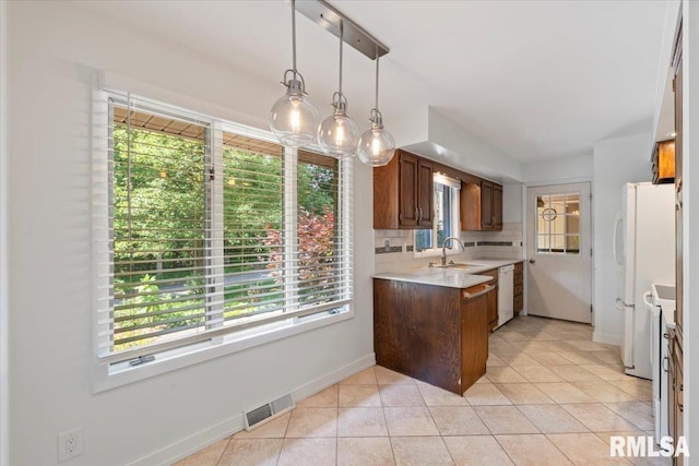 4319 7th Ave, Moline, IL 61265 - kitchen with light countertops, tasteful backsplash, light tile patterned floors, white appliances, and hanging light fixtures