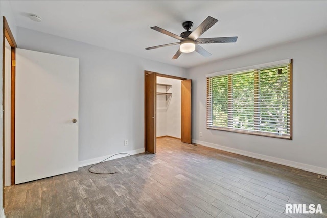 4319 7th Ave, Moline, IL 61265 - unfurnished bedroom with wood finished floors, a closet, ceiling fan, and a walk in closet