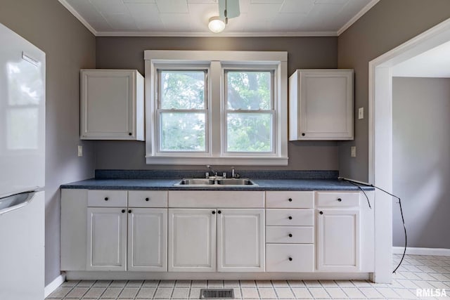 614 S Calumet St, Marion, IL 62959 - kitchen featuring freestanding refrigerator, dark countertops, ornamental molding, and white cabinetry