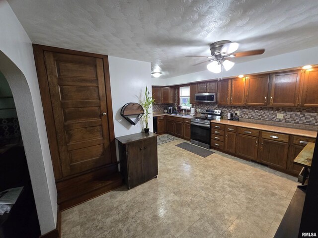 610 NW 6th St, Aledo, IL 61231 - kitchen featuring appliances with stainless steel finishes, arched walkways, ceiling fan, and tasteful backsplash