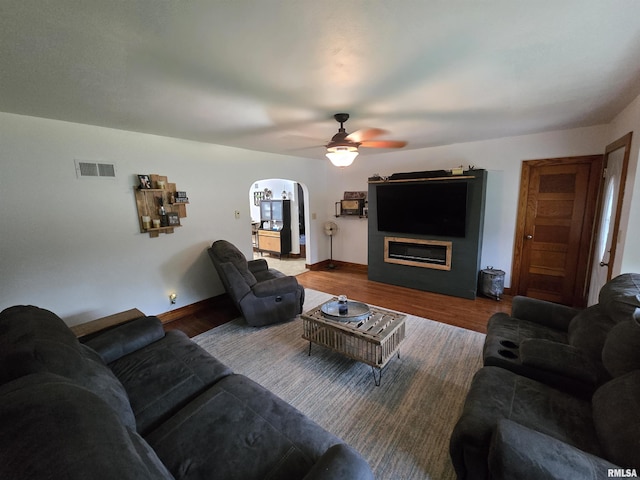 610 NW 6th St, Aledo, IL 61231 - living area featuring a ceiling fan, arched walkways, wood finished floors, and a glass covered fireplace
