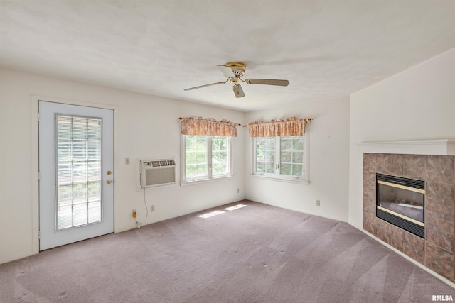 3626 15th Avenue Ct, Moline, IL 61265 - unfurnished living room featuring carpet floors, an AC wall unit, a tiled fireplace, and a ceiling fan