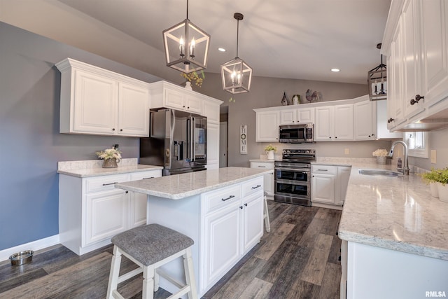 101 Prairie View Ct, Clinton, IA 52732 - kitchen featuring appliances with stainless steel finishes, vaulted ceiling, a kitchen island, white cabinets, and a chandelier