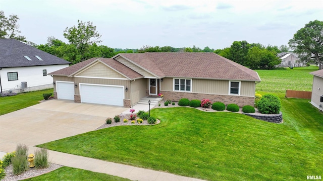 101 Prairie View Ct, Clinton, IA 52732 - view of front facade featuring a garage, brick siding, driveway, and a front lawn