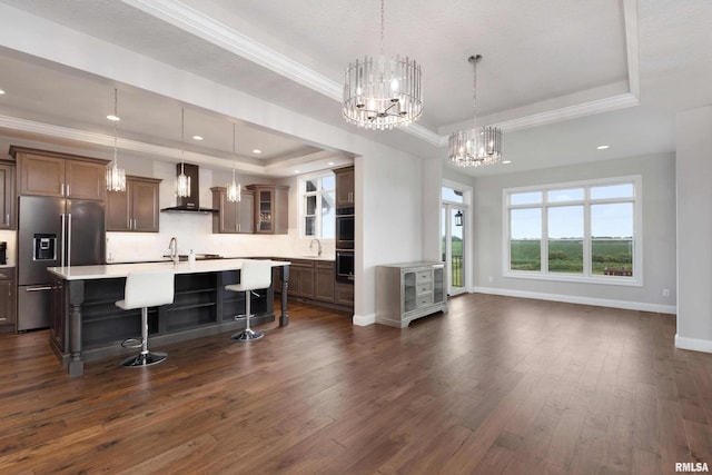 5541 Pigeon Creek Rd, Bettendorf, IA 52722 - kitchen with high quality fridge, a tray ceiling, wall chimney range hood, double oven, and light countertops
