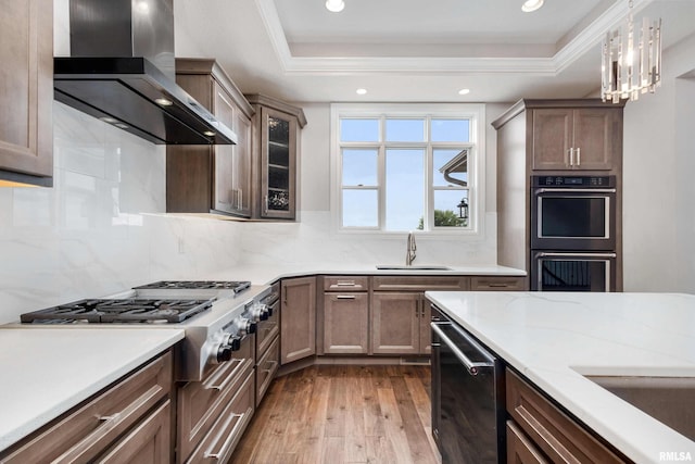 5541 Pigeon Creek Rd, Bettendorf, IA 52722 - kitchen with wall chimney range hood, a raised ceiling, wood-type flooring, dishwashing machine, and recessed lighting