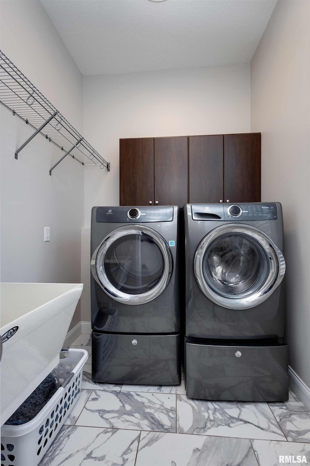 5541 Pigeon Creek Rd, Bettendorf, IA 52722 - laundry area featuring light marble finish floors, cabinet space, and washer and dryer