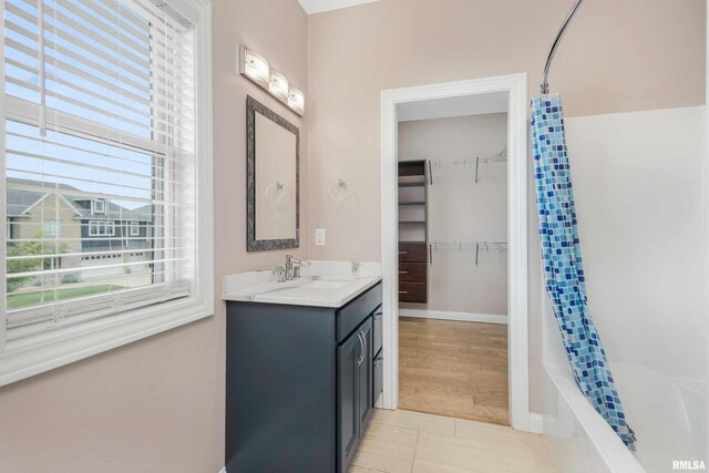 5541 Pigeon Creek Rd, Bettendorf, IA 52722 - bathroom featuring vanity, plenty of natural light, shower / bathtub combination with curtain, and a spacious closet