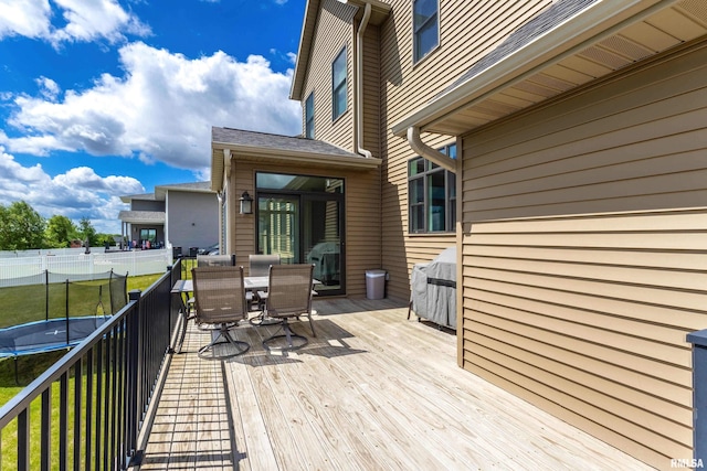 5541 Pigeon Creek Rd, Bettendorf, IA 52722 - deck featuring a trampoline and outdoor dining space